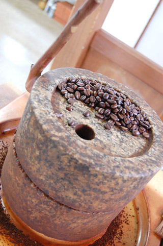 石臼でコーヒー豆を挽く